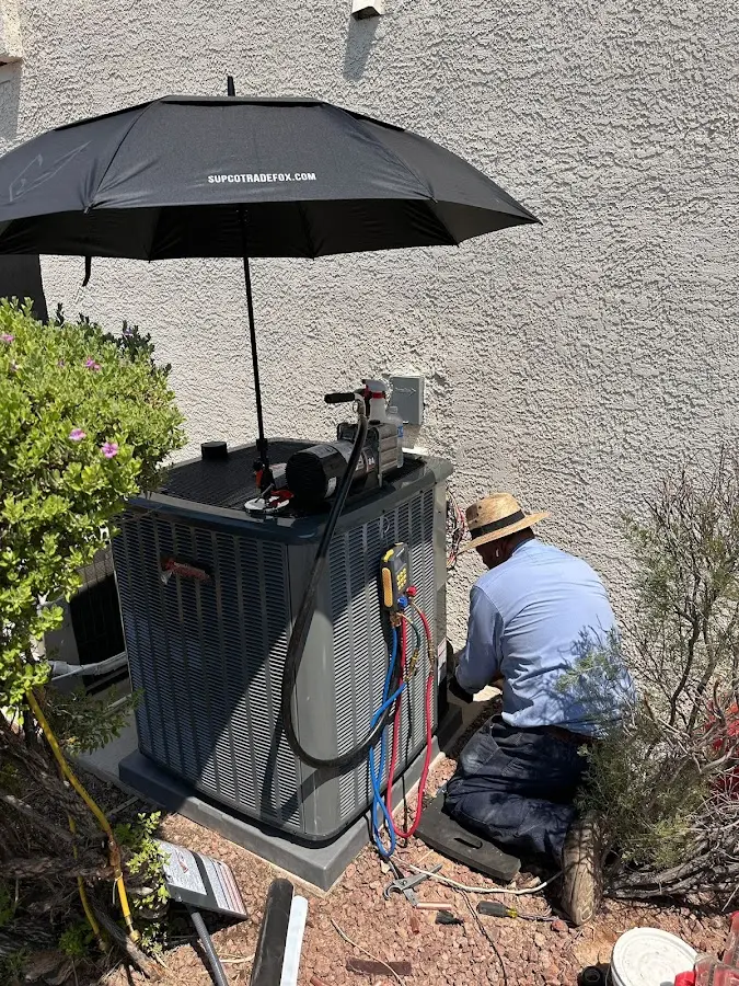 HVAC technician performing outdoor AC maintenance in North Providence